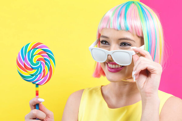 Woman in a colorful wig with a lollipop