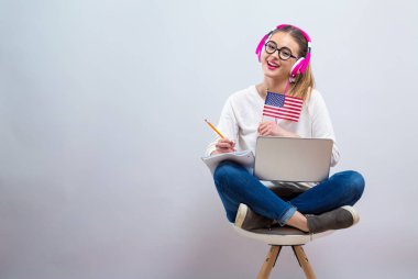 Young woman with USA flag using a laptop computer clipart