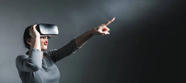 Giovane donna utilizzando un auricolare realtà virtuale — Foto Stock