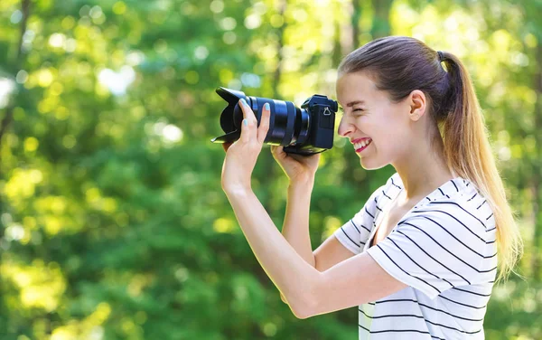 Jeune femme avec une caméra professionnelle — Photo
