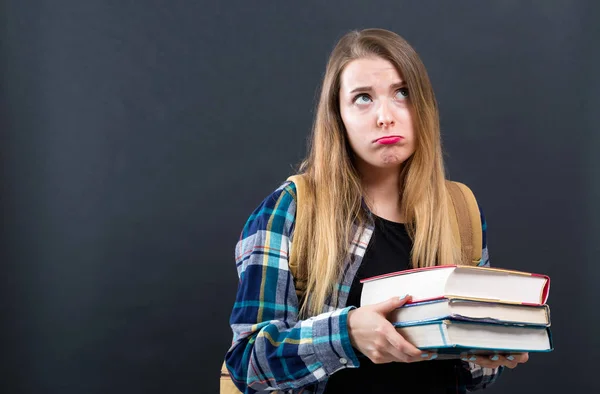 Triste joven estudiante con un montón de libros de texto —  Fotos de Stock