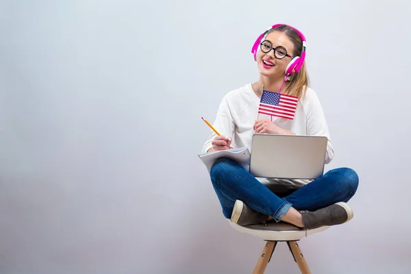 Giovane donna con bandiera USA utilizzando un computer portatile — Foto Stock