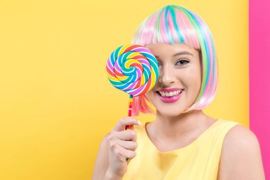 Bir lolipop ile renkli bir peruk kadında