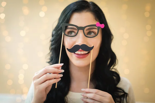 Jeune femme avec des lunettes en papier et des bâtons de moustache — Photo