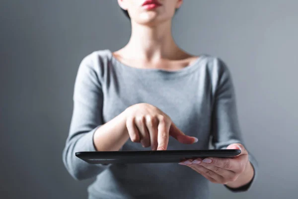 Jonge vrouw die haar tablet gebruikt — Stockfoto