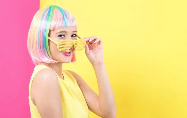 Kobieta ubrana migawki odcienie okulary w kolorowe peruki — Zdjęcie stockowe