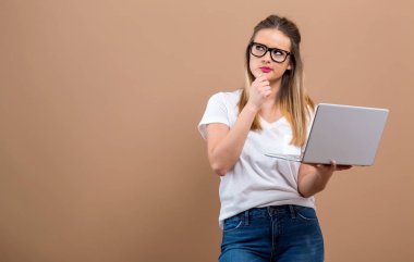 Düşünceli bir poz bir dizüstü bilgisayar ile genç kadın