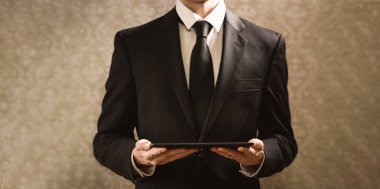 Elinde tablet bilgisayar tutan bir işadamı