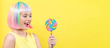 Bir lolipop ile renkli bir peruk kadında