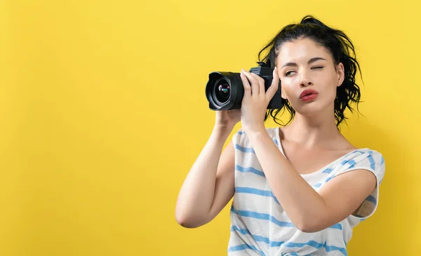 Giovane donna con una fotocamera professionale — Foto Stock