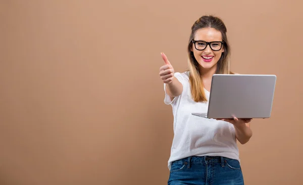 Giovane donna con un computer portatile che dà pollice in su — Foto Stock