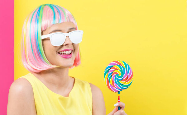 Woman in a colorful wig with a lollipop