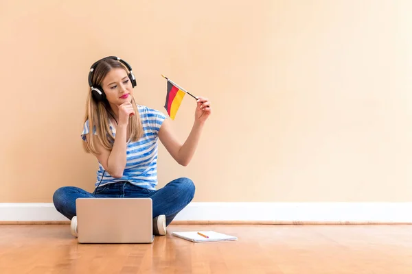 Young woman with Germany flag using a laptop computer — Stock Photo, Image