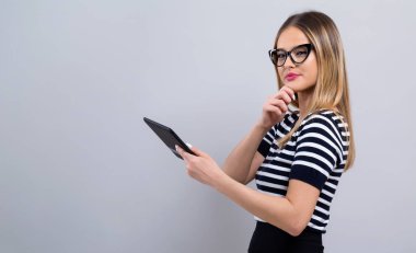 Tablet bilgisayarı olan genç bir kadın