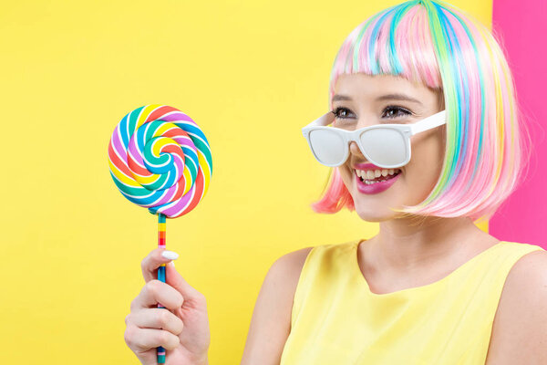 Woman in a colorful wig with a lollipop