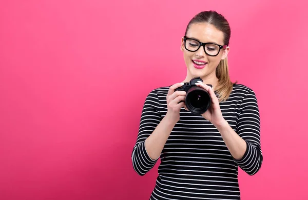 Giovane donna con una fotocamera professionale — Foto Stock