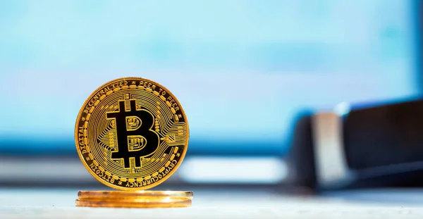 Bitcoin moneta criptovaluta con uno schermo del computer portatile in background — Foto Stock