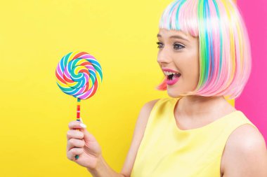 Bir lolipop ile renkli bir peruk kadında