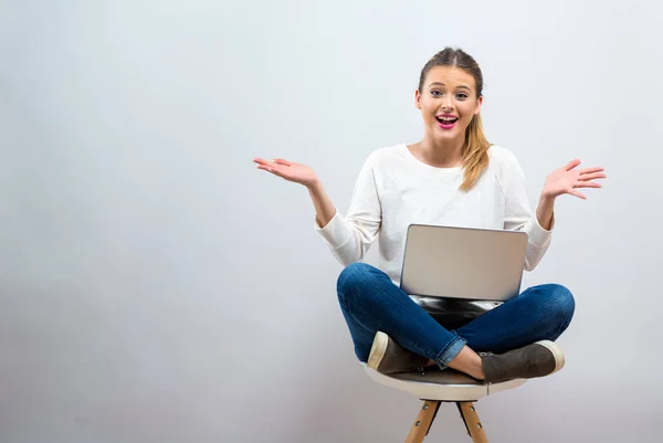 Verrast jonge vrouw met een laptopcomputer — Stockfoto