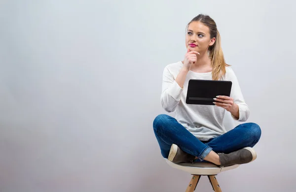 Jonge vrouw met een tablet computer — Stockfoto