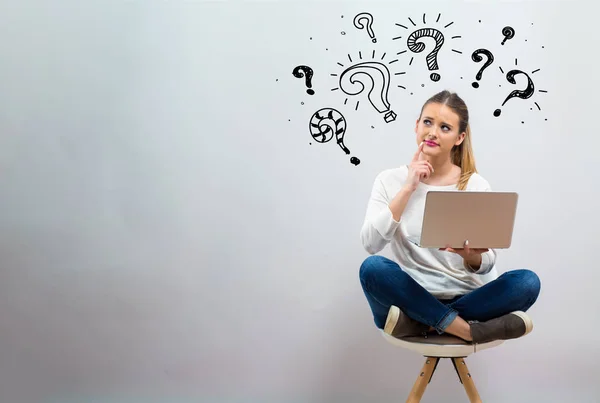 Vraagtekens met jonge vrouw haar laptop gebruikt — Stockfoto