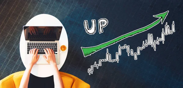 Market up trend chart with person using a laptop