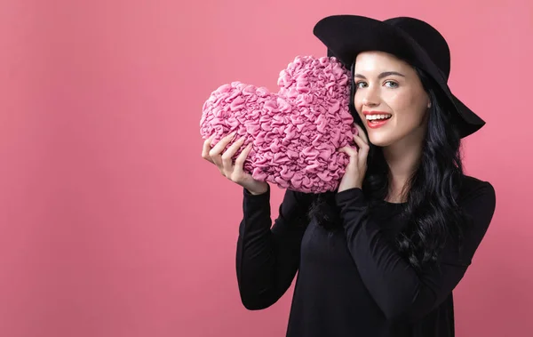 Женщина держит подушку сердца в тему Дня Святого Валентина — стоковое фото