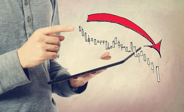 Marknaden ner trenddiagram med man innehar en surfplatta — Stockfoto