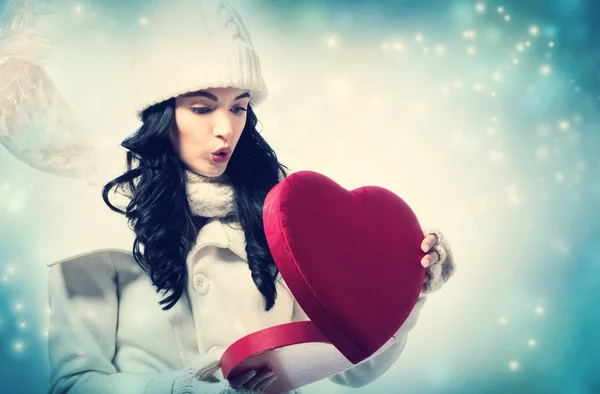 Young woman holding a big heart gift box — Stock Photo, Image