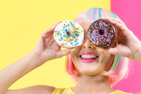 Красивая женщина в красочном парике с пончиками — стоковое фото