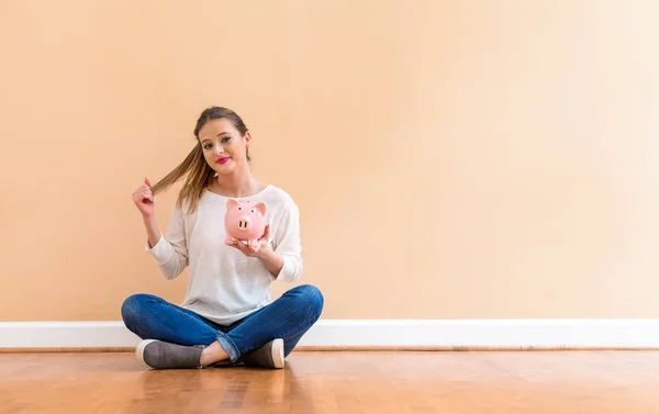 Giovane donna con un salvadanaio — Foto Stock