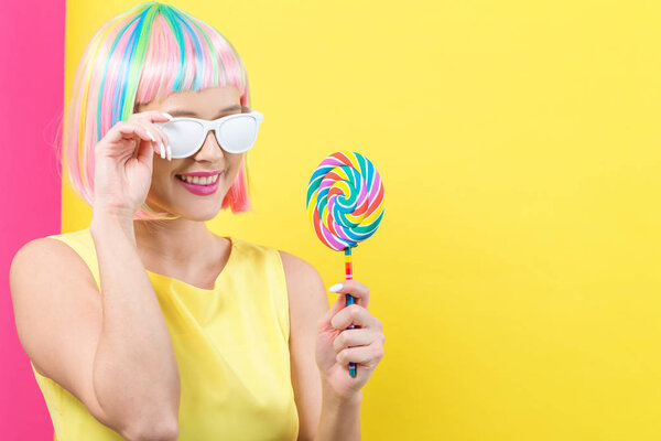 Woman in a colorful wig with a lollipop