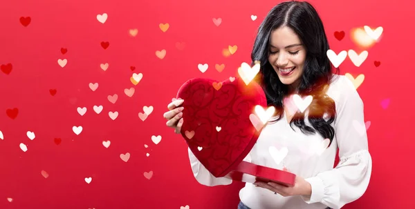 Feliz joven mujer sosteniendo una gran caja de regalo de corazón — Foto de Stock