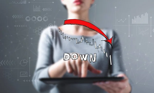Market down trend chart with business woman using a tablet computer