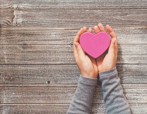 Persona che tiene in mano una scatola a forma di cuore — Foto Stock