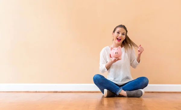 Mujer joven con una alcancía — Foto de Stock