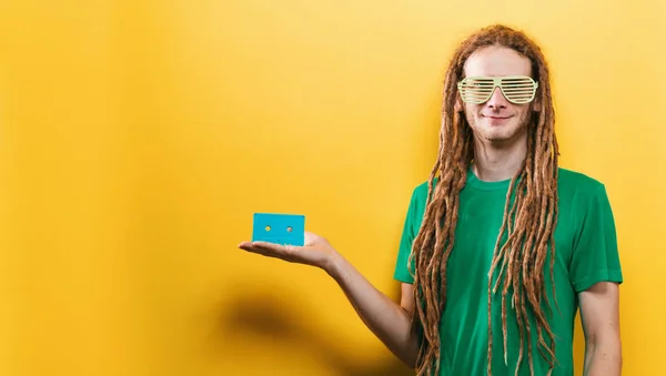 Homem feliz segurando uma fita cassete retro — Fotografia de Stock