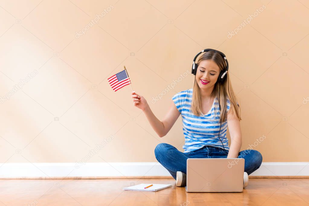 Young woman with USA flag using a laptop computer