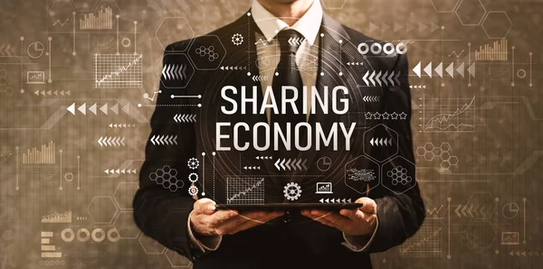 Sharing economy with businessman holding a tablet computer on a dark vintage background