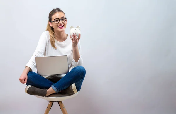 Mladá žena s prasátko a laptop — Stock fotografie