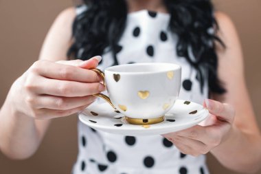 Elinde kahve tutan genç bir kadın.