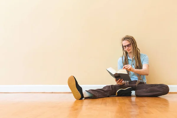 Молодой человек в очках читает книгу — стоковое фото