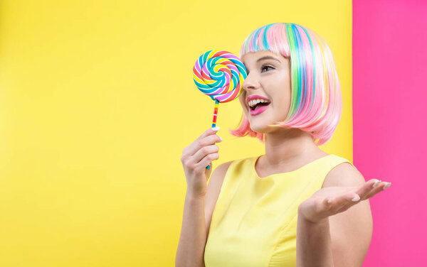 Женщина в красочном парике с леденцом
