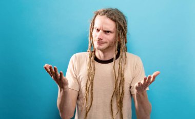 Sağlam bir arka plan üzerinde şaşırmış genç adam