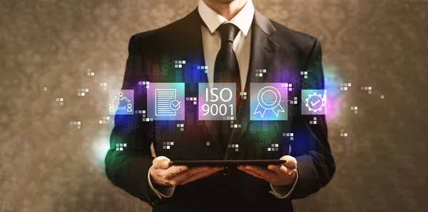 ISO 9001 con empresario sosteniendo una tableta —  Fotos de Stock