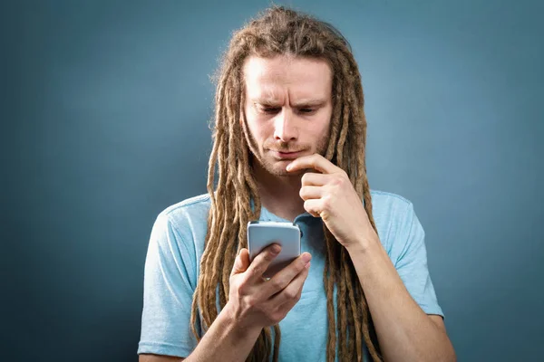 Un joven mirando su celular — Foto de Stock