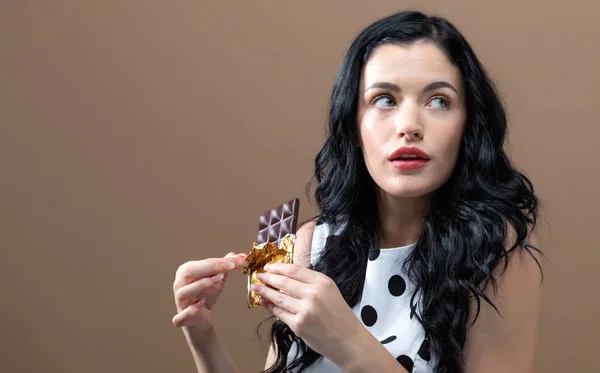 Mujer joven sosteniendo chocolate — Foto de Stock