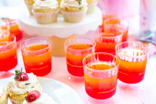 Mesa de postres con gelatina y cupcakes — Foto de Stock