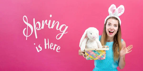 De lente is hier bericht met vrouw met Easter basket — Stockfoto