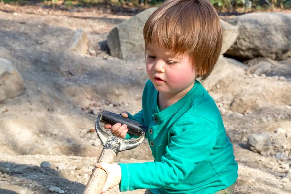 Niño cavando con una pala —  Fotos de Stock